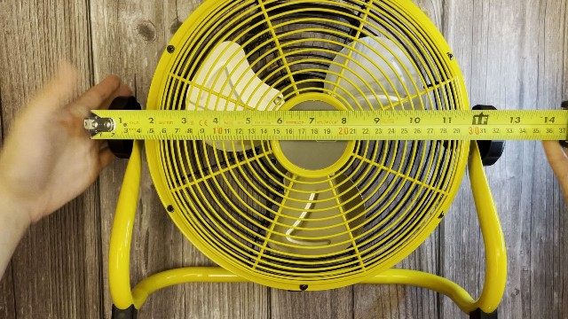 The author measuring the packed size of the Geek Aire Portable Camping Fan.