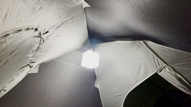 The LuminAID PackLite Titan on its brightest white light setting, at the top of a tent.