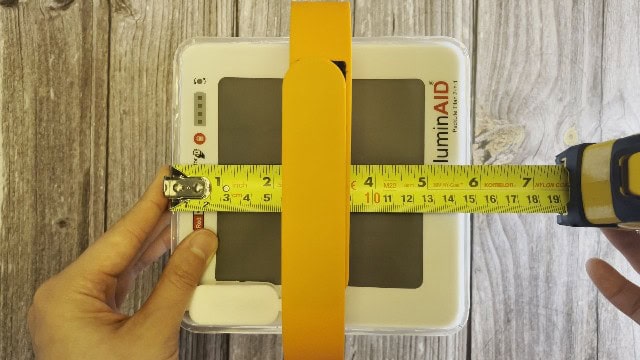 The author measuring the packed size of the LuminAID PackLite Titan.