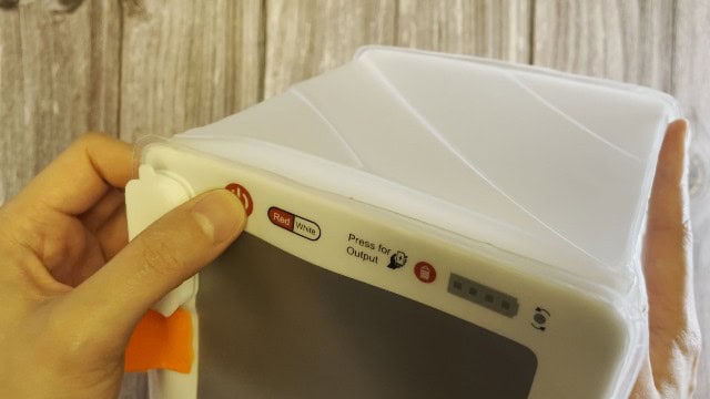 The author pressing the power button of the LuminAID PackLite Titan.