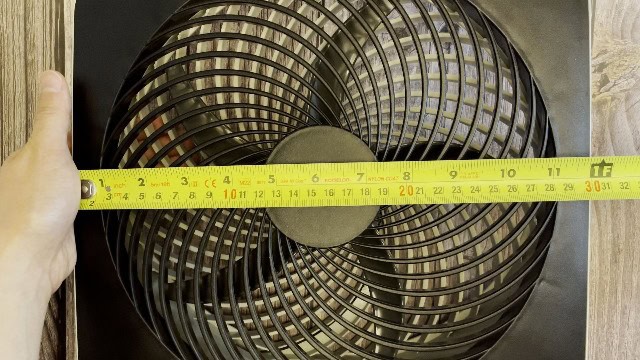 The author measuring the fan size of the O2Cool Treva Fan.