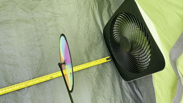 The author measuring the airflow distance of the O2Cool Treva in a camping tent.