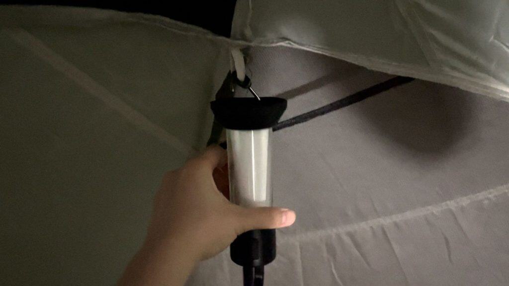 The Ledlenser ML6 hanging by its metal hook to a tent
