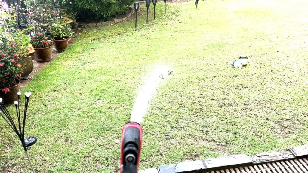 The author using a water hose to rain test the Ledlenser ML6